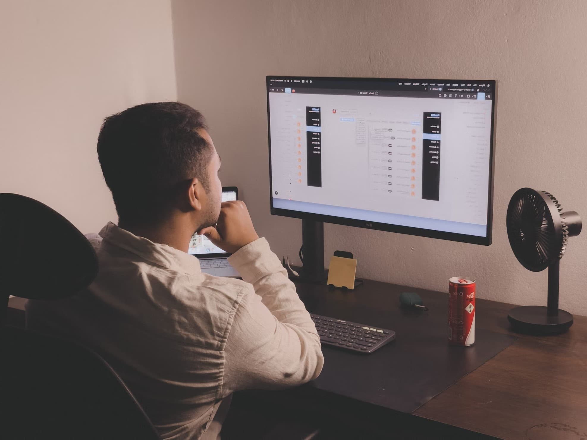 Imagem de um homem de costas analisando em um computador.